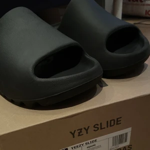 Yeezy slides Onyx - Säljer mina yeezy slides. De är använda, men i bra skick med box och KVITTO. De är i storlek 40 2/3 och om ni har frågor eller funderingar är det bara att höra av sig!
