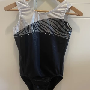 Gymnastikdräkt  - Knappt använd Gymnastikdräkt i storlek M men passar XS-M. Vit och svart med stenar och glitter. Pris kan diskuteras 