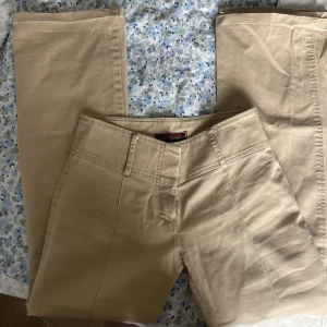Utsvängda jeans - Beiga utsvängda jeans som är uppsprättade längst ner för att passa någon som är 166cm, skriv vid frågor 🩷står storlek 38 men passar mer som en 36