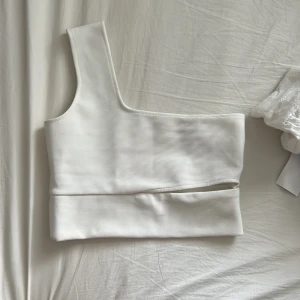 Oneshoulder - Oneshoulder topp från Gina tricot med ”skärnings” detalj i mitten. Storlek S, använd 1 gång men för liten tyvärr