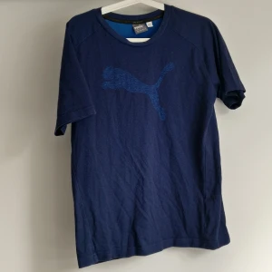 Blå t-shirt  - Blå lite melerad t-shirt i bomull, med tryck över bröstet. Bra träningströja eller vardagströja. Köparen står för frakt