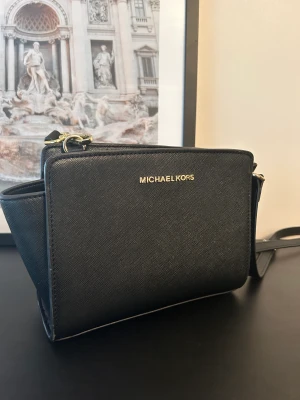 Michael Kors väska - Använd men i fint skick. Finns ett till helsvart axelband till.  
