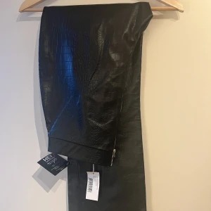 Fejk skinn byxa. - Fejk skinnbyxa, med slits och dragkedja. 