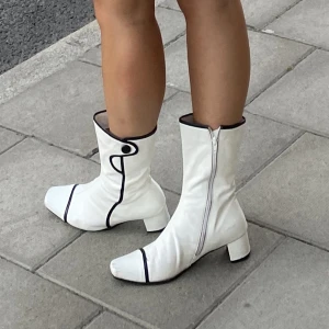 Vita stövlar  - Vita vintage stövlar med svarta detaljer. Har tappat ena knappen och har även lite defekter/smuts. Nyligen omklackade. 