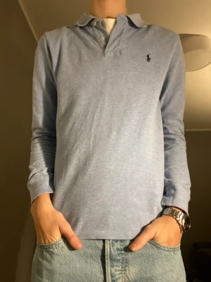 PRL rugbytröja - Ljusblå snygg rufbytröja från ralph lauren. Storlek S (14-16) tröjan är i oanvänt skick. Han på bilden är 170cm. Kontakta vid frågor om fler bilde osv 