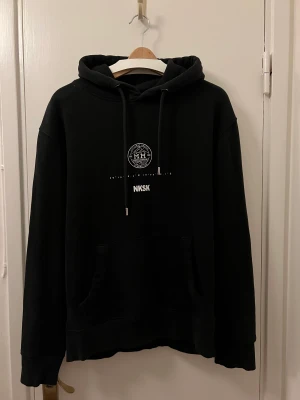Hoodie med tryck - En svart hoodie med tryck, storlek M, från NK. Collab NKSK x MM. Bra kvalite