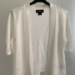 Vit kofta  - Supersöt vit kortärmad kofta i mycket fint skick, säljer då den aldrig kommit till användning. Storlek L men sitter som en S