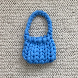 Stickad väska - Säljer denna stickade väska som är handgjord av mig. Super fin blå färg, fått många komplimanger för väskan då den är annorlunda. På bilderna skiftar den färg pga olika ljus