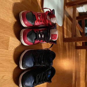 Två par skor nike - Båda skorna är rätt så använda där av att ena skon har en heel drag. Medans den andra skon är i ett okej till bra läge.