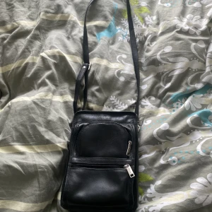 Axelremsväska  - Svart Dilana axelremsväska, den har inte använts. Den är rymlig och har 5 olika fickor