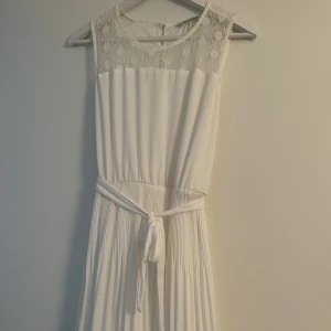 Studentklänning  - Säljer denna fina vita klänning som passar perfekt till studenten. Använd en gång. Från vero moda storlek 42 men mer som en M 