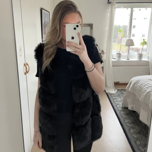 Pälsväst  - Svart pälsväst. Fuskpäls!