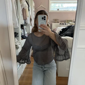 Grå blus med volang ärmar  - En superfin grå blus, med volang ärmar.