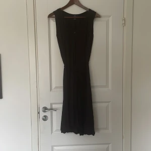 Klänning Filippa K - Lång svart klänning. Tunn. Ena öglan för snöret i midjan sönder annars i fint skick. 
