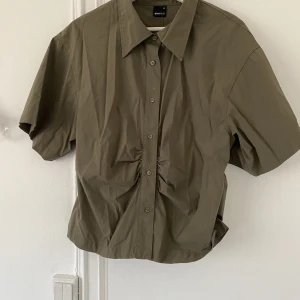 Skjorta, Militärgrön - Militärgrön figursydd skjorta. Normal i storleken. Använd två gånger. 