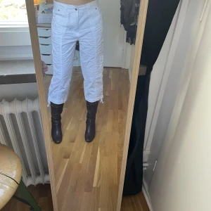 Cargo pants - Vita cargo byxor, tre kvarts längd. Dom är lite genomskinliga men syns ej så mycket! Väldigt fina detaljer med mycket fickor och i fint skick!
