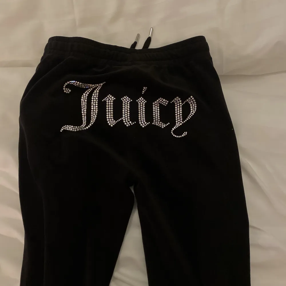 Juicy Couture hela settet i svart, byxor, zip hoodie och bandeau top! Knappt använt så inga defekter, väldigt bra skick! Skriv för fler bilder🤍. Jeans & Byxor.