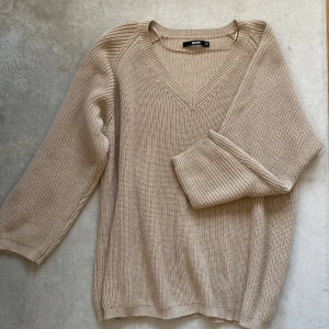 Oversized stickad tröja  - En oversized beige stickad tröja från BIKBOK. Använd fåtal gånger. Storleken är i XS/S men fungerar lika bra upptill L!
