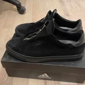 Arigato skor - Svarta Arigato skor med zip, fortfarande i bra skick. Använd ett par gånger men som sagt fortfarande i bra skick och inga stora skråmor. Säljes pga av storlek.