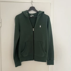 Ralph Lauren hoodie - Säljer min riktigt snygga hoodie från raffe i en klassiskt grön cw med vit logga. Fint skick, storlek XS passar S. Hojta till för mer bilder eller info! 💫