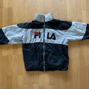 Fila jacka - Fila jacka som går att vända ut och in. Har luva som går att vika in i kragen. Står ingen storlek i, men  sitter oversized på mig som är 160cm. Har några slitningar, kan skicka bild/beskrivning vid förfrågan, men annars i gott skick🌟