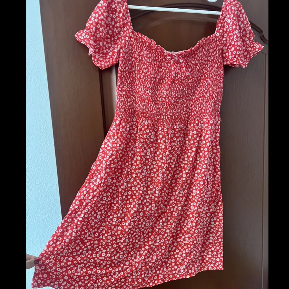 Röd blommig klänning (sundress), aldrig använd med prislapp kvar. Köpt för 10 euro. Klänningar.