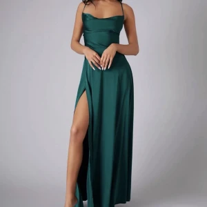 Grön balklänning  - Smaragdgrön balklänning i sidenmaterial köpt på shein förra året. Bra kvalite!! Snöras i ryggen och har en slit på ena sidan. (Jag är 174 och har klackar på bilden)