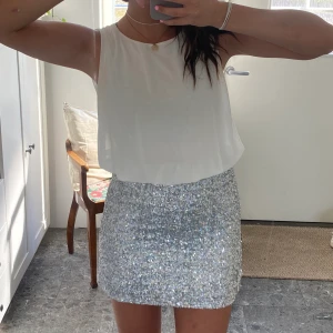 Finkläning - Kort snygg klänning med vit överdel och silverfärgad nertill med paljetter i storlek M. 