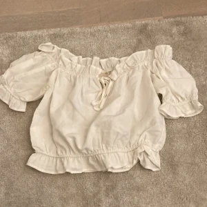 Sommar topp - En jätte fin och härlig sommar topp. I nyskick har aldrig använt. Den är i en kortare modell med volanger. Perfekt under sommaren som nu kommer. Vid intresse kan närmare och bättre bilder skickas om det skulle viljas. Hoppas det finns intresse:)