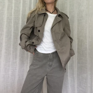 Kort trench - Snygg!!! Kort trench. Fattas två knappar som är lätta att sy dit. Dock ser man inte det om den bara är öppen   Jag är vanligtvis en storlek s och 164cm lång. Glöm ej mina andra annonser 💌