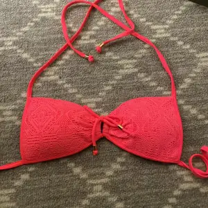 En neon rosa bikini top som knyts både runt nacken och runt om