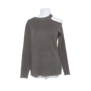 Ribbad tröja  - En långarmad grön ribbad tröja med hål vid ena axeln, slits vid sidorna. Använd max 2-3 gånger 