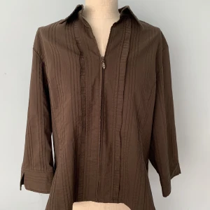 Brun topp - Brun topp med dragkedja från stadsmissionen. Skulle säga att storleken är S men funkar på en XS och mindre M.