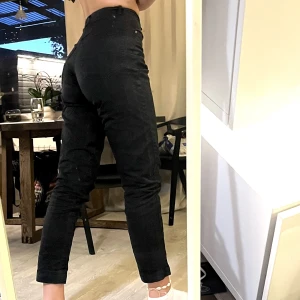 Svarta jeans - Svarta högmidjade jeans som sitter tajt runt midjan men lite lösare runt smalbenen. Säljer pga. att de är lite för små för mig.