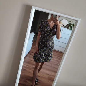 Blommig klänning - Elegant blommig klänning från Vero Moda I storlek s. Formar kurvorna fint! Varsamt använd.