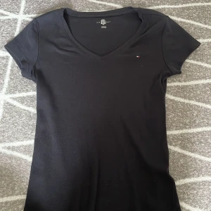 V-ringad Tommy Hilfiger topp - En nästan oanvänd topp från Tommy i bäsa skick. Storlek M.
