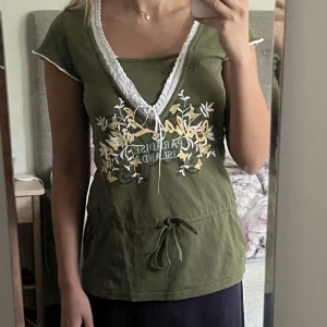 Grön 2000s topp - Supersöt grön 2000s topp med tryck och knytdetaljer. Begagnat skick, några stygn har gått upp runt den ena knytdetaljen, men det är verkligen inget som märks. Storlek M men passar även S🫶💕💕