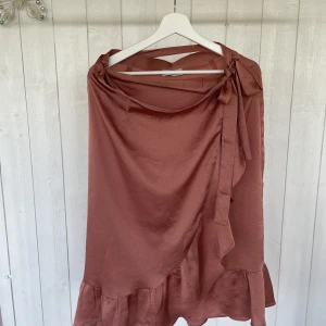 Omlottkjol - En supersnygg omlottkjol i rostfärgad nyans.  Något litet mörke finns där en tråd har lossnat. 