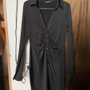 Svart mini klänning - Svart tajt klänning från Nelly, knapparna längst framsidan gör den mer figursydd vilket får den att sitta väldigt fint💗