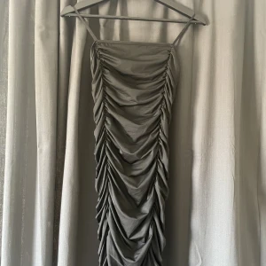 Svart klänning - En skitsnygg ruched klänning som formar kroppen och är i väldigt gott skick.