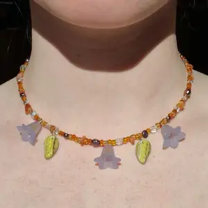 Litet sött halsband med blåklockor och orangea pärlor i glas samt karneol