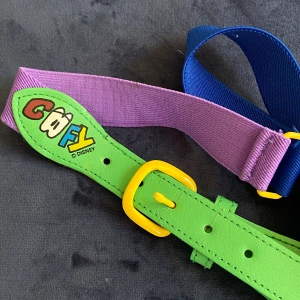 Färgglatt bälte Disney  - Fint skärp i härliga färger. 70 cm långt och den lila och blåa delen är stretchiga.  Tecken på användning syns lite vid hålen.