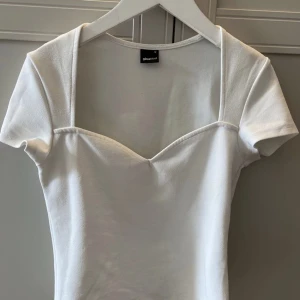 Topp med hjärtformad urringning - Supersöt topp/ tshirt med hjärtformad urringning från Gina Tricot. Köp direkt: 170kr