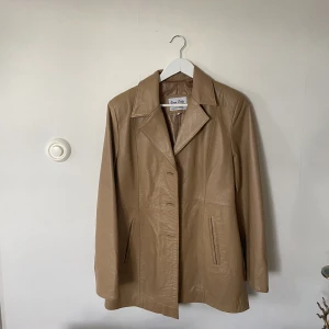 Brun skinnkappa  - Brun /beige skinnkappa, italienska märket Vera Pelle, Strl S/M.  Bra skick utöver att två knappar fattas där fram men kan stängas med en, annars fin som öppen. 