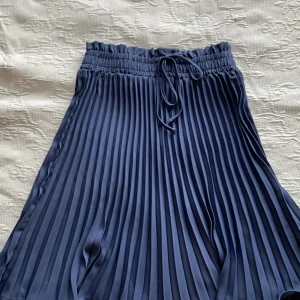 Ribbad kjol - Mörkblå medellång kjol med knytsnöre i midjan. Aldrig använd. Kontakta vid intresse eller fler frågor. Köparen står för frakt💓