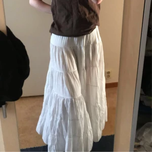 Vit maxikjol - Säljer denna vackra långkjol som är i bra skick! Kjolen är ca 72cm i midjan och 90cm lång. Kan bäras både lågmidjat, mid, eller högmidjat. Väldigt bekväm att gå i!