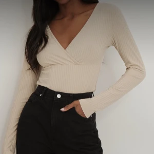 Ribbade toppar med överlapp - Topp, stl. 36 (S), Dam Dessa toppar är ribbade och har en v-ringning, en omlottframsida och långa ärmar. Ena toppen är grön och andra är beige. Välj 1 för 80kr eller båda för 140kr. 