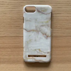 Ett mobil skal med motiv av marmor. Det är lite slitet på kanterna men det syns knappt. Det är från ideal of Sweden. Det är till iPhone 6/7/8 och SE 🩷