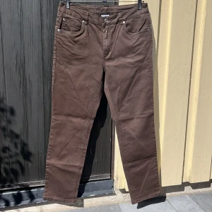Bruna jeans - Ett par mellanbruna, stretchiga jeans i fint skick. Åtsittande och har fyra fungerande fickor. 67% bomull 29% polyester 4% elastan.