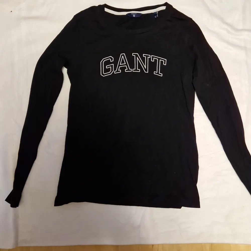 Svart T-shirt med lång ärm från Gant i stl XS. Oanvänd. Frakt tillkommer enligt nedan. T-shirts.